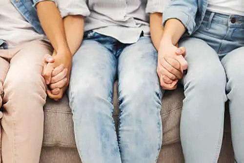 Young adults hold hands during an honesty exercise