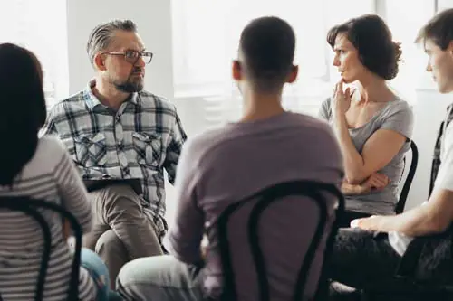 A group of people in a DUI addiction treatment program sit in a circle